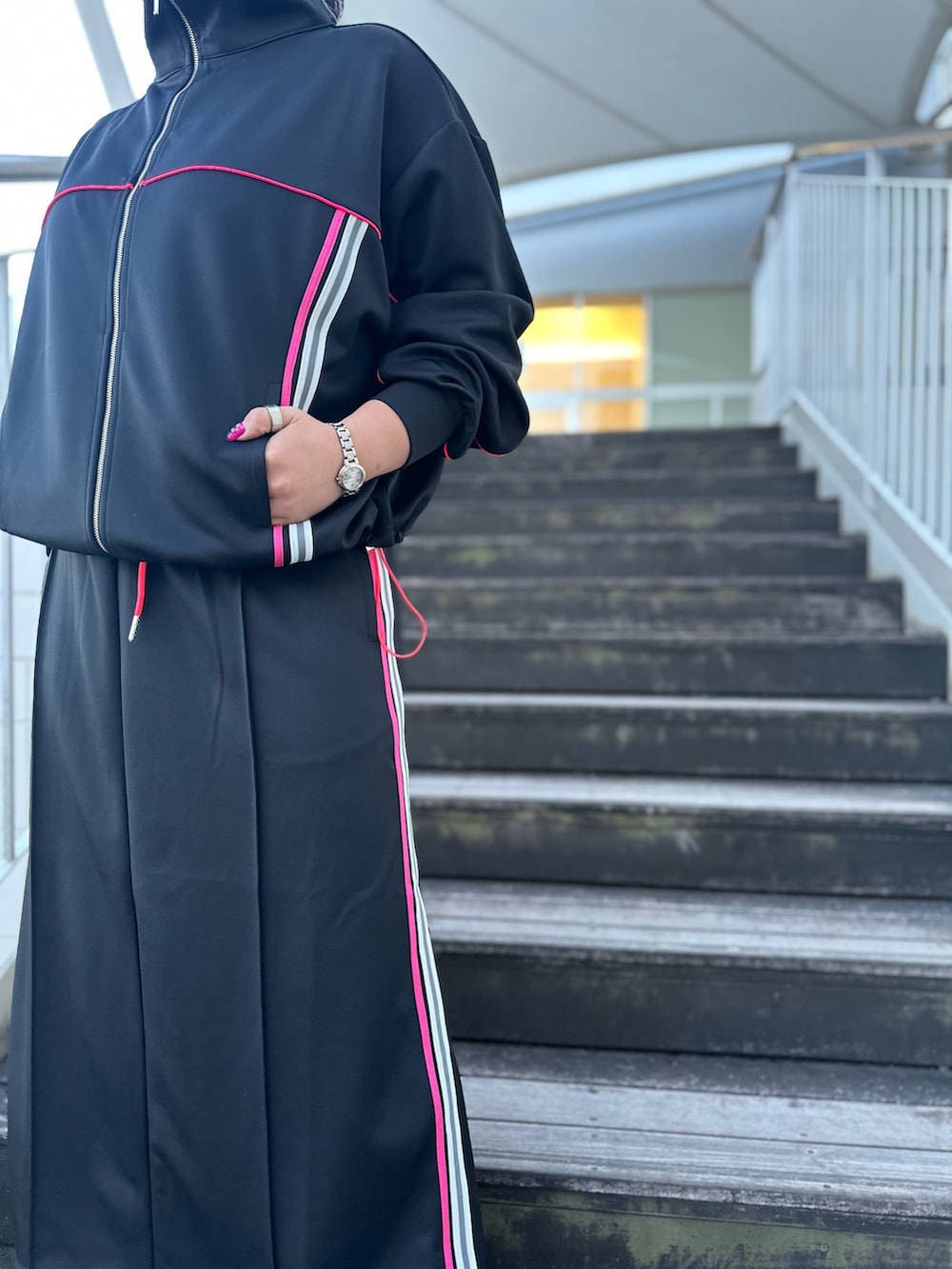 ブラック系のその他アウター、ブラック系のスカート、シルバー系のスニーカーを着用したレディースの冬コーディネートの4枚目の写真