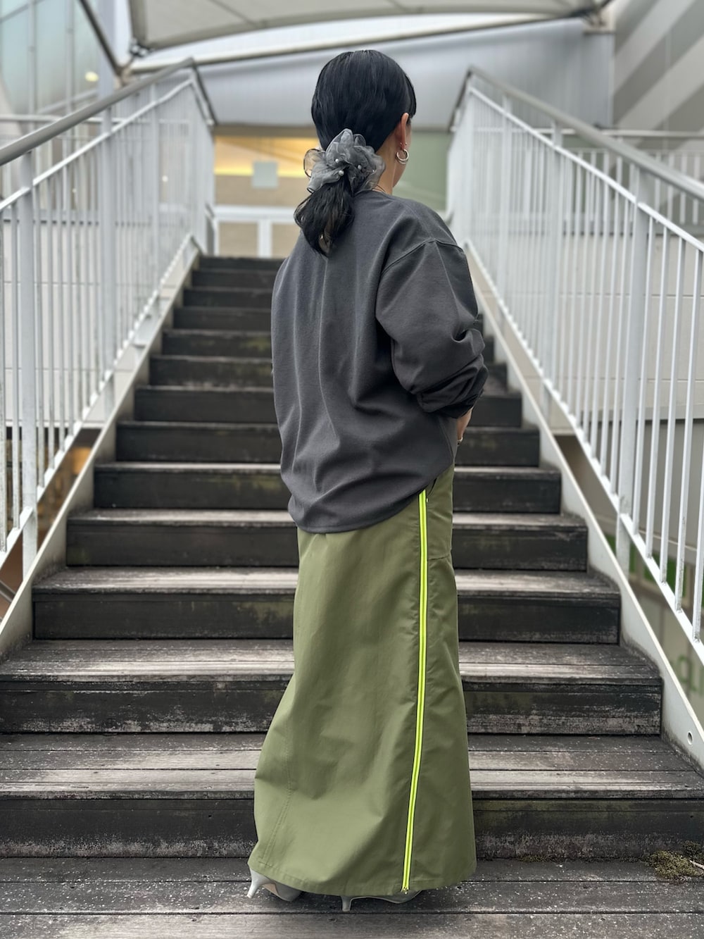 グリーン系のスカート、グレー系のTシャツ/カットソーを着用したレディースの冬コーディネートの3枚目の写真