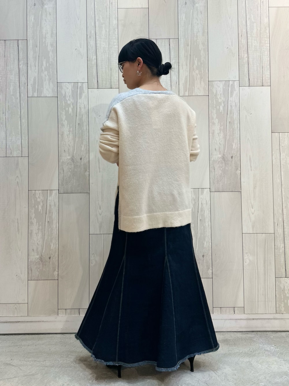 グレー系のニット/セーター、ブルー系のデニムスカートを着用したレディースの冬コーディネートの5枚目の写真