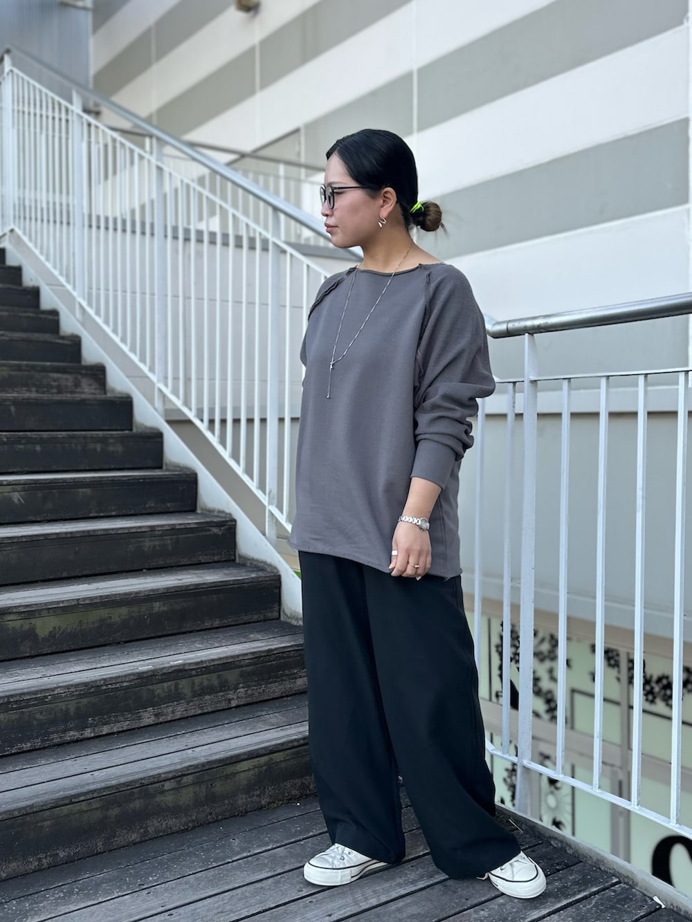 グレー系のスウェット、ブラック系のスラックス、ホワイト系のスニーカーを着用したレディースの冬コーディネートの3枚目の写真