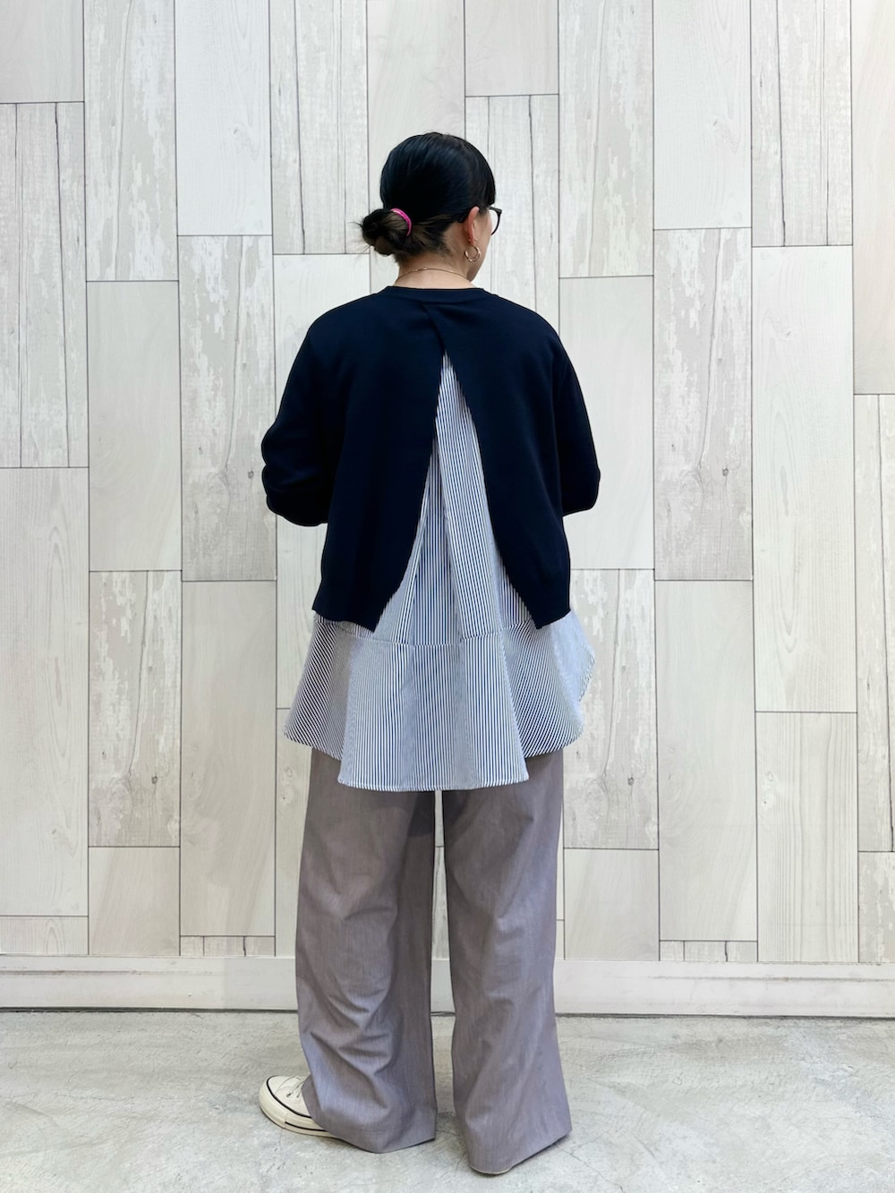 グレー系のスラックス、ホワイト系のスニーカーを着用したレディースの冬コーディネートの4枚目の写真