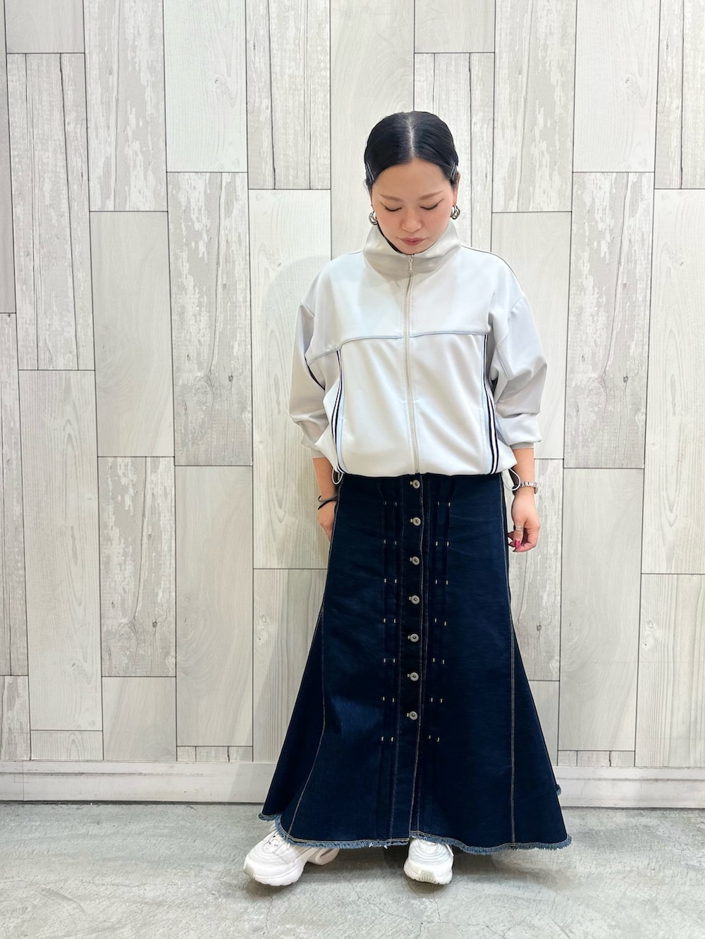 グレー系のその他アウター、ブルー系のデニムスカート、ホワイト系のスニーカーを着用したレディースの春コーディネートの3枚目の写真