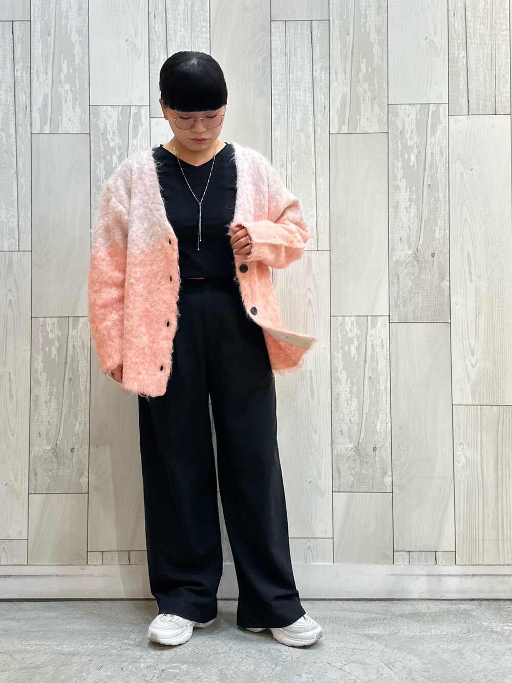 ピンク系のカーディガン/ボレロ、ブラック系のスラックス、ブラック系のTシャツ/カットソーを着用したレディースの冬コーディネートの2枚目の写真