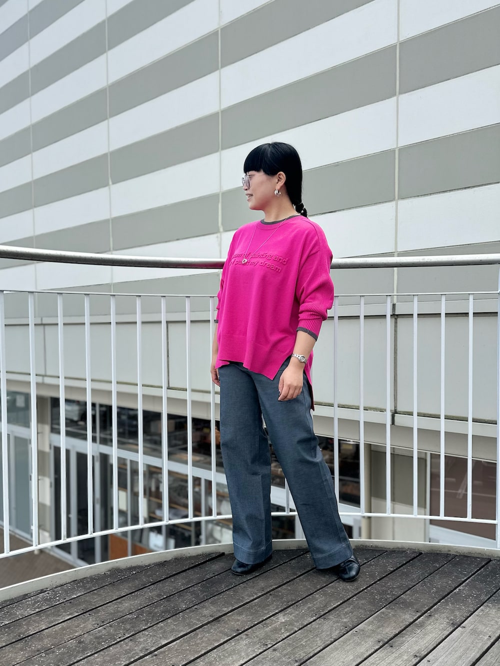 ピンク系のニット/セーター、ブラック系のブーツ、グレー系のデニムパンツを着用したレディースの秋コーディネートの3枚目の写真