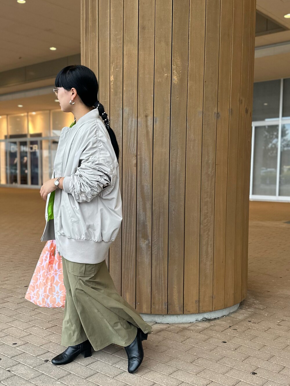 ブラック系のニット/セーター、ベージュ系のMA-1、グリーン系のスカートを着用したレディースの秋コーディネートの3枚目の写真