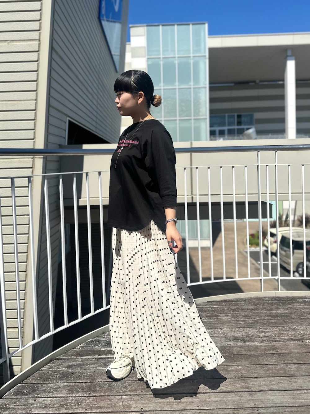 ブラック系のTシャツ/カットソー、ホワイト系のスカートを着用したレディースの春コーディネートの4枚目の写真