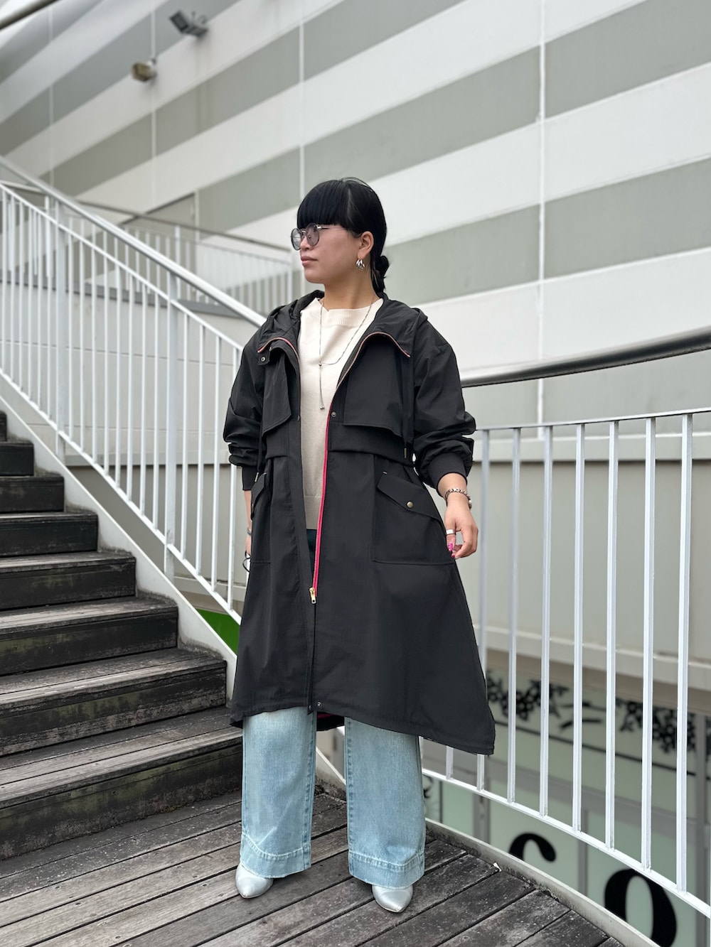 グレー系のミリタリージャケット、ブルー系のデニムパンツを着用したレディースの冬コーディネートの3枚目の写真