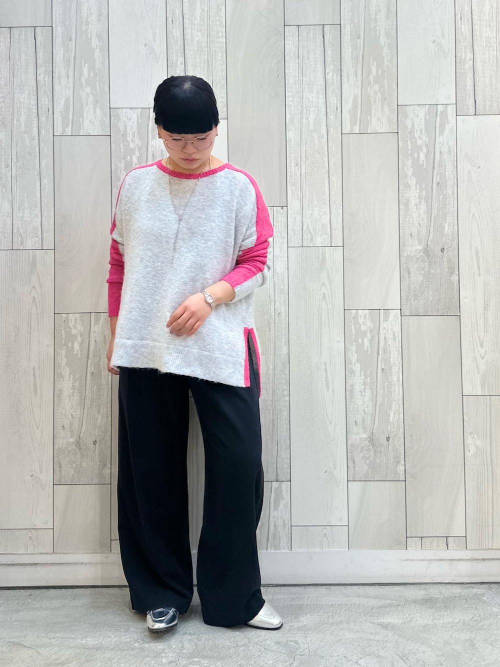 ブラック系のスラックス、シルバー系のローファー、グレー系のニット/セーターを着用したレディースの冬コーディネートの2枚目の写真