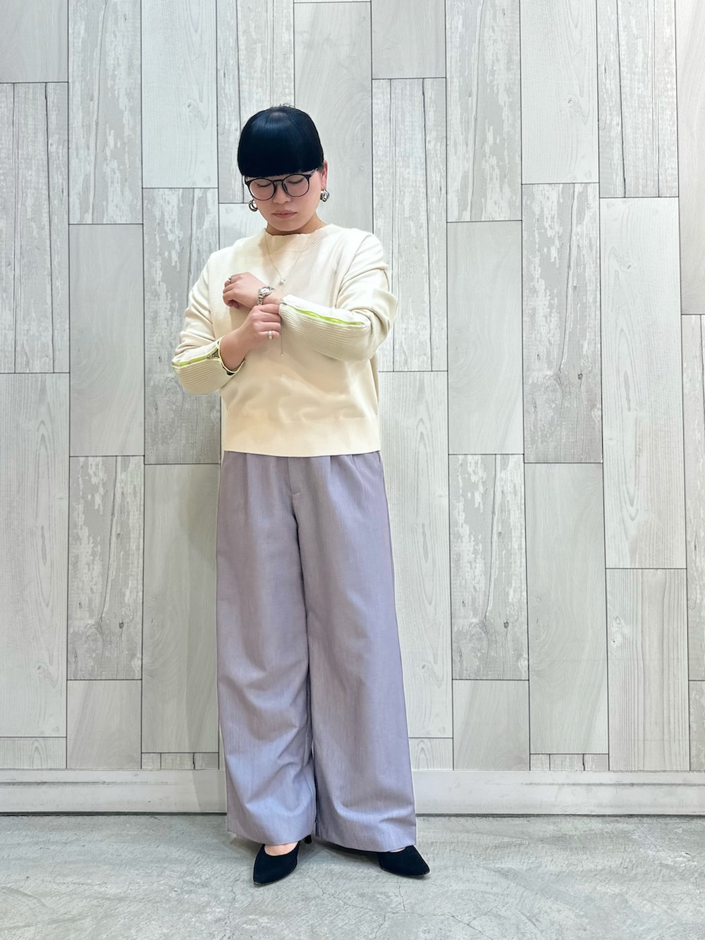 ホワイト系のニット/セーター、グレー系のスラックスを着用したレディースの冬コーディネートの2枚目の写真