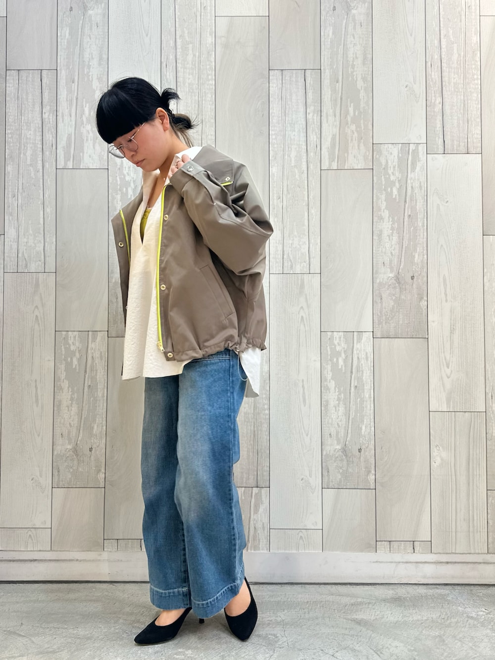 ホワイト系のシャツ/ブラウス、グリーン系のマウンテンパーカー、イエロー系のタンクトップを着用したレディースの冬コーディネートの2枚目の写真