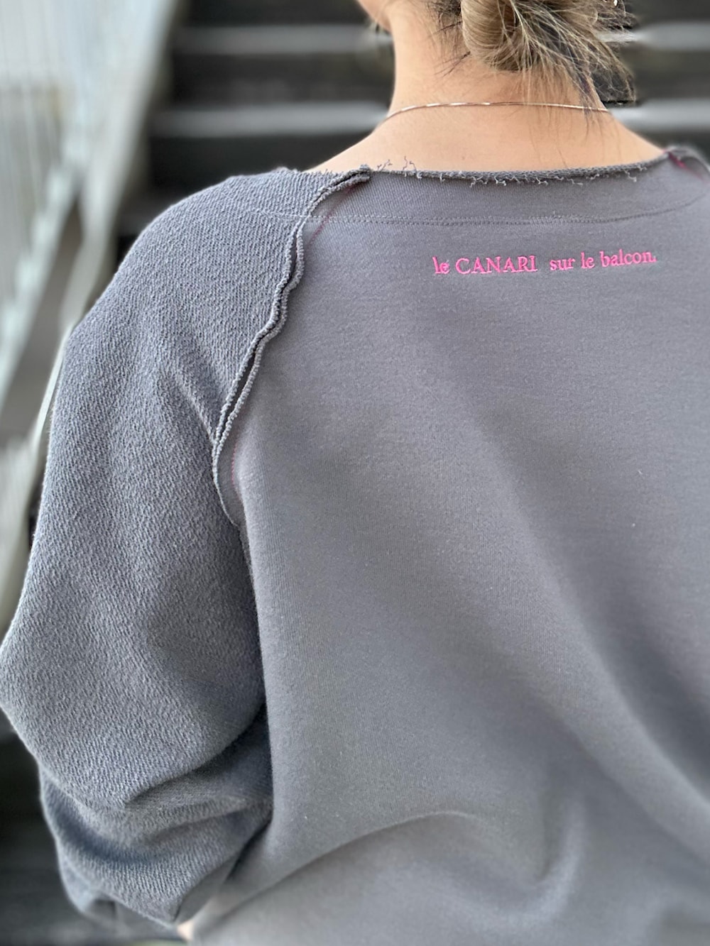 グレー系のスウェット、ブラック系のスラックス、ホワイト系のスニーカーを着用したレディースの冬コーディネートの5枚目の写真