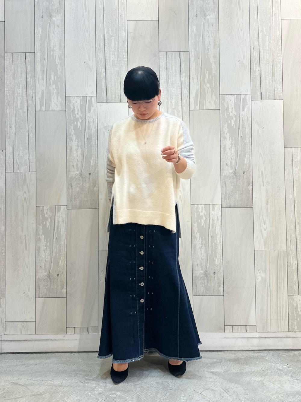グレー系のニット/セーター、ブルー系のデニムスカートを着用したレディースの冬コーディネートの2枚目の写真