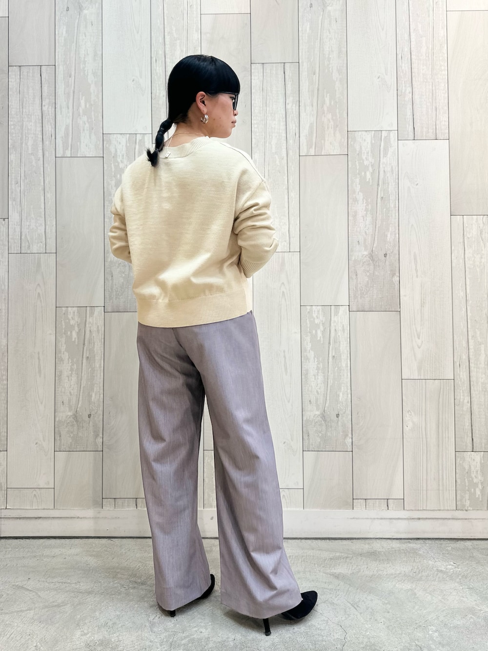 ホワイト系のニット/セーター、グレー系のスラックスを着用したレディースの冬コーディネートの3枚目の写真