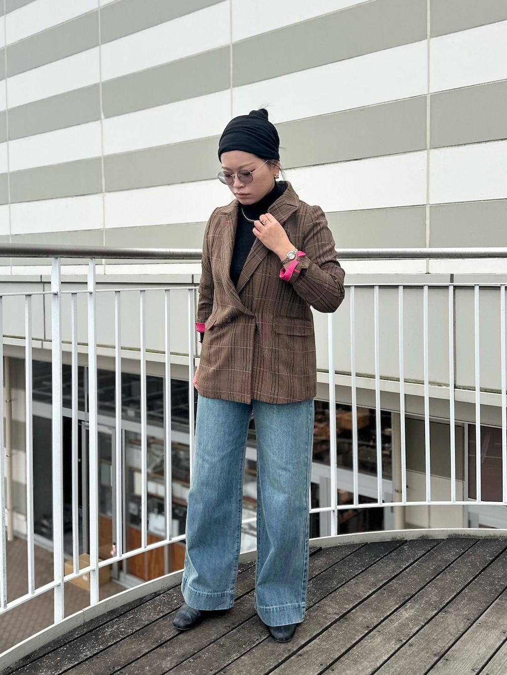 ブラック系のTシャツ/カットソー、ブラウン系のテーラードジャケット、ブルー系のデニムパンツを着用したレディースの秋コーディネートの2枚目の写真