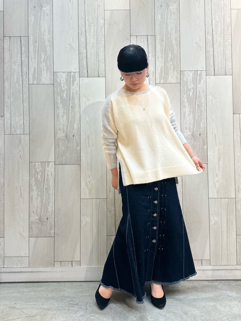 グレー系のニット/セーター、ブルー系のデニムスカートを着用したレディースの冬コーディネートの3枚目の写真