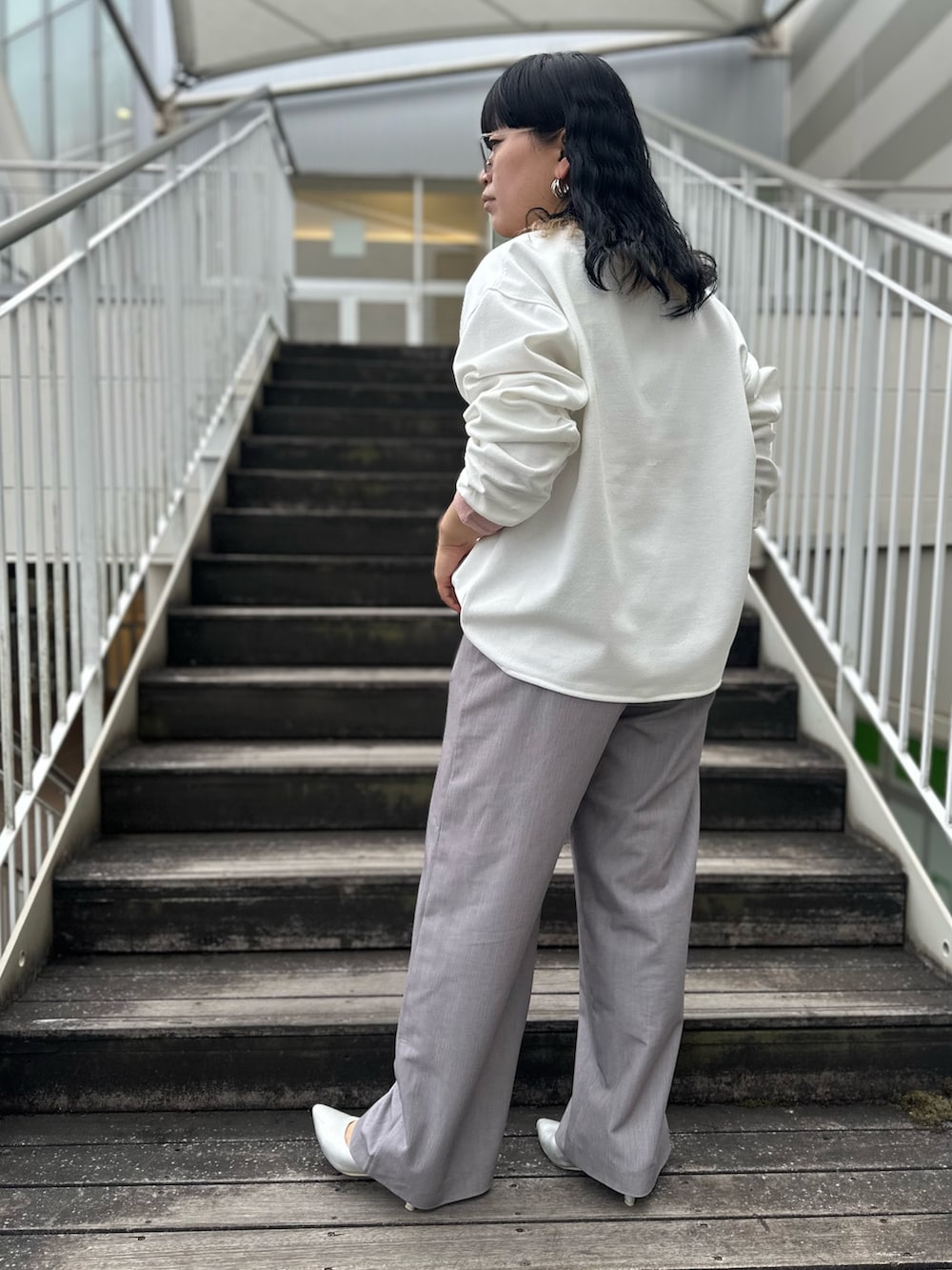 ホワイト系のTシャツ/カットソー、ピンク系のTシャツ/カットソー、グレー系のスラックスを着用したレディースの冬コーディネートの3枚目の写真