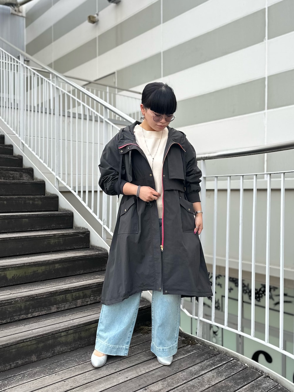 グレー系のミリタリージャケット、ブルー系のデニムパンツを着用したレディースの冬コーディネートの2枚目の写真