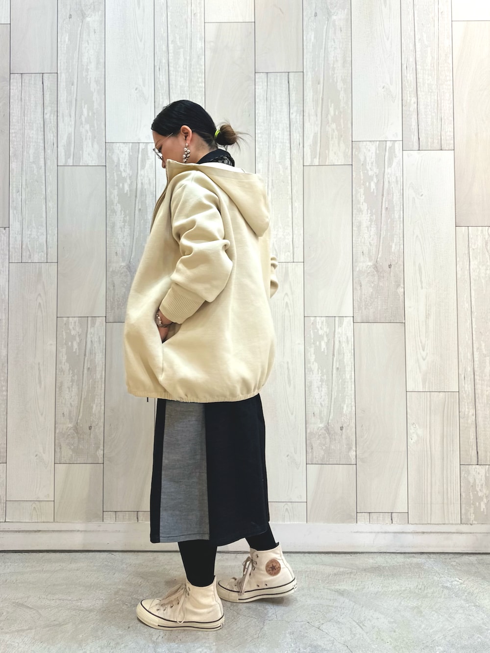 ブラック系のデニムジャケット、ホワイト系のパーカー、ホワイト系のスニーカーを着用したレディースの冬コーディネートの3枚目の写真