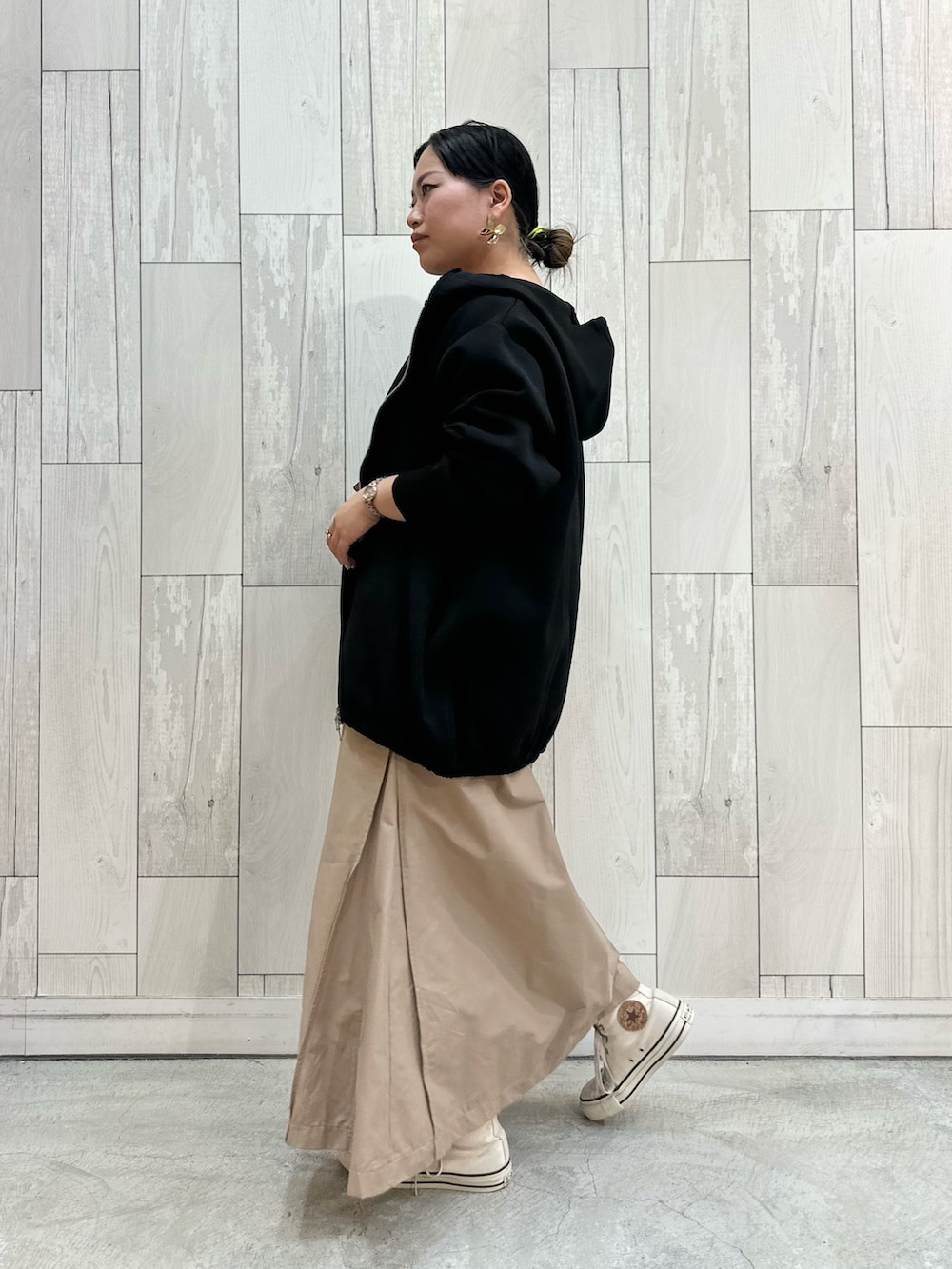 ベージュ系のワンピース、ブラック系のパーカー、ホワイト系のスニーカーを着用したレディースの冬コーディネートの4枚目の写真