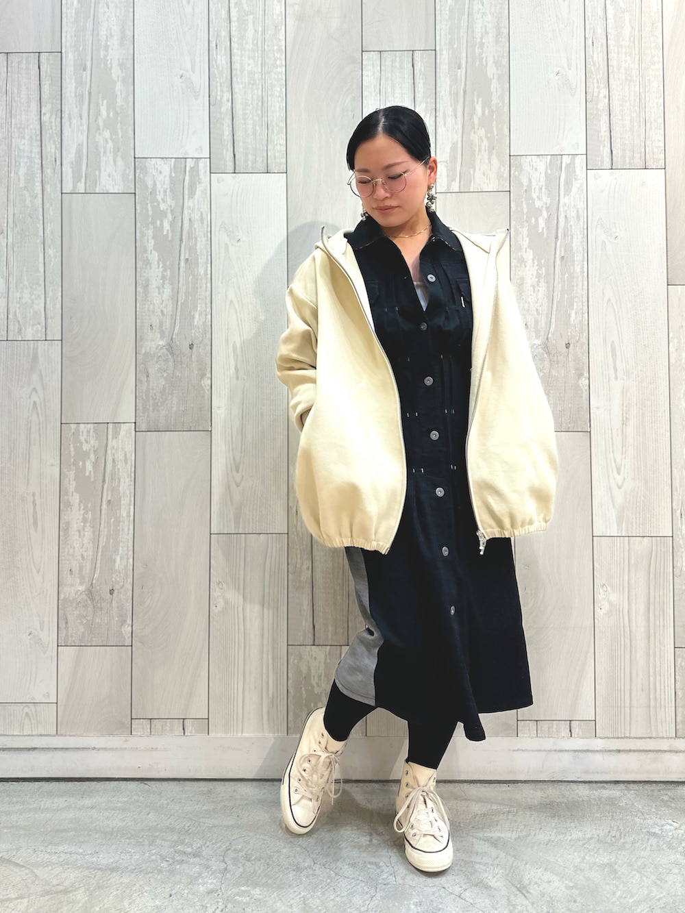 ブラック系のデニムジャケット、ホワイト系のパーカー、ホワイト系のスニーカーを着用したレディースの冬コーディネートの2枚目の写真