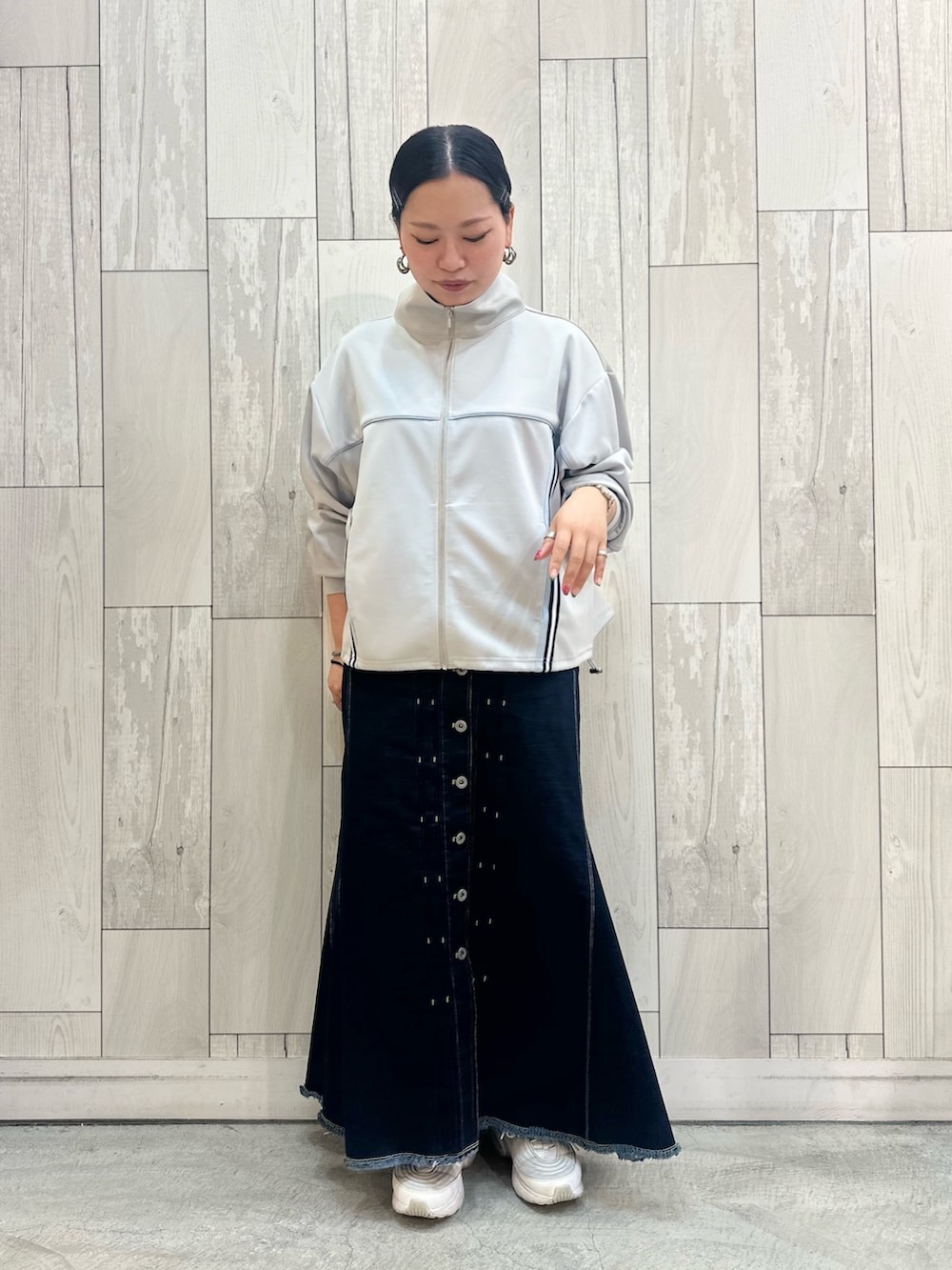 グレー系のその他アウター、ブルー系のデニムスカート、ホワイト系のスニーカーを着用したレディースの春コーディネートの2枚目の写真