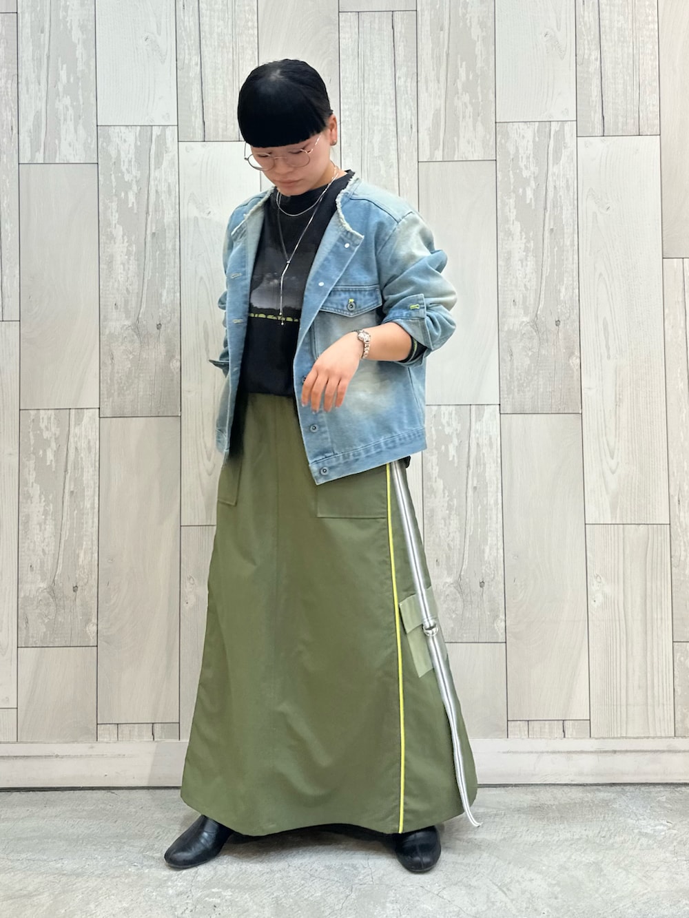 グリーン系のスカート、ブルー系のデニムジャケット、グレー系のTシャツ/カットソーを着用したレディースの冬コーディネートの3枚目の写真