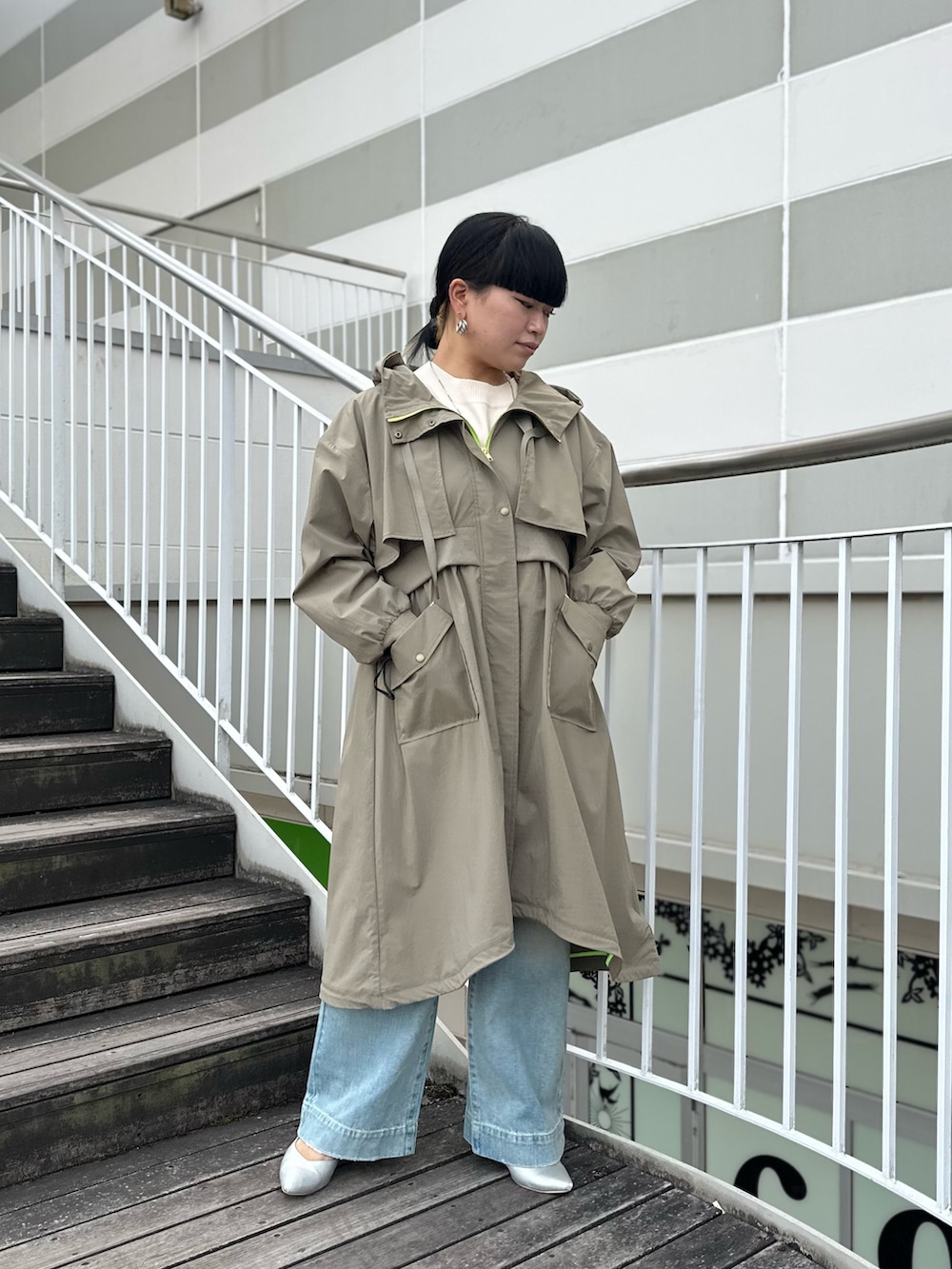 グリーン系のミリタリージャケット、ホワイト系のニット/セーター、ブルー系のデニムパンツを着用したレディースの冬コーディネートの3枚目の写真