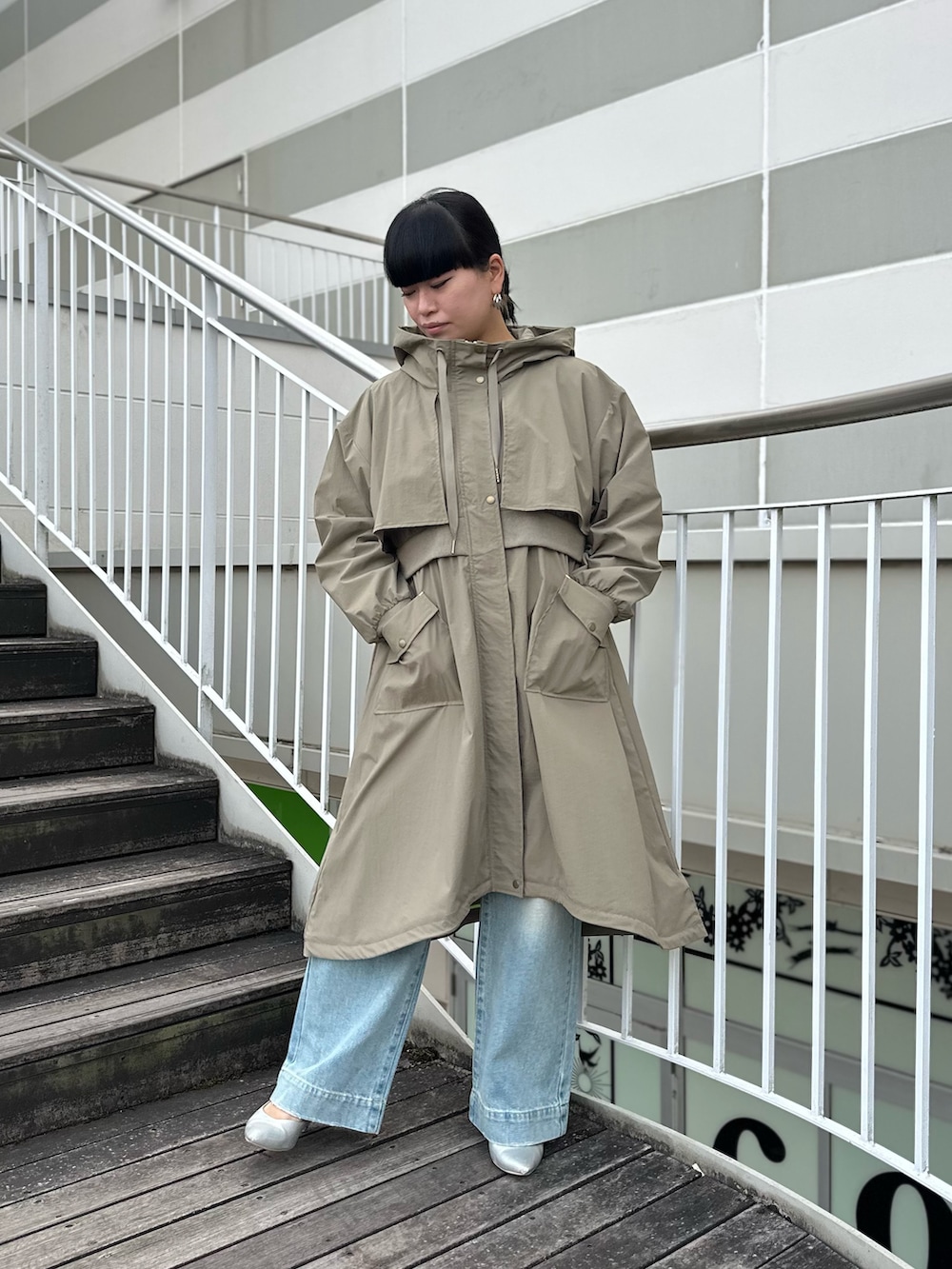 グリーン系のミリタリージャケット、ホワイト系のニット/セーター、ブルー系のデニムパンツを着用したレディースの冬コーディネートの5枚目の写真