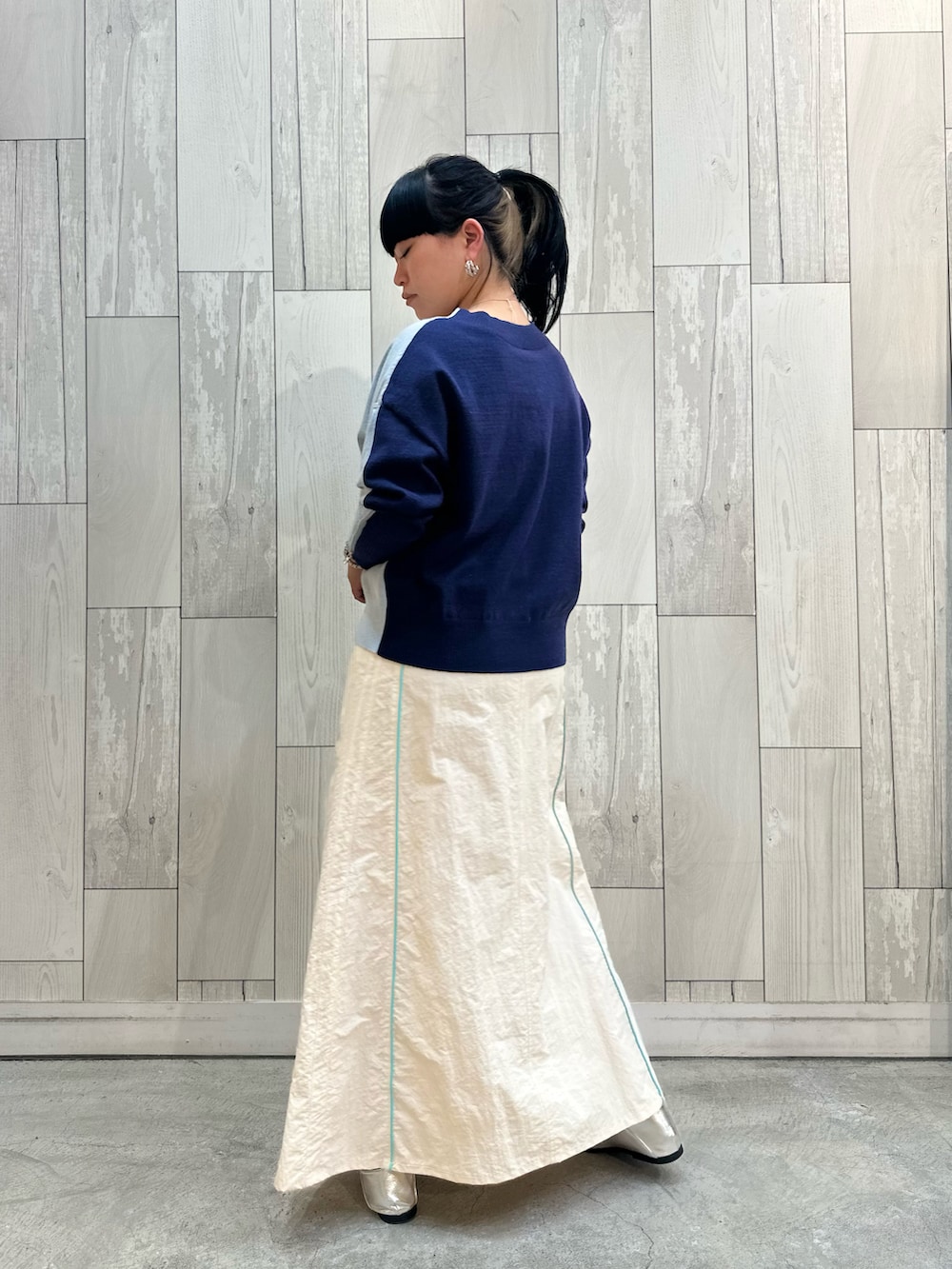 ブルー系のニット/セーター、ホワイト系のデニムスカート、シルバー系のローファーを着用したレディースの冬コーディネートの4枚目の写真