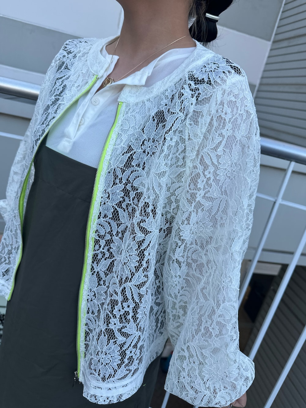 グリーン系のワンピース、ホワイト系のブルゾン、ホワイト系のTシャツ/カットソーを着用したレディースの春コーディネートの2枚目の写真