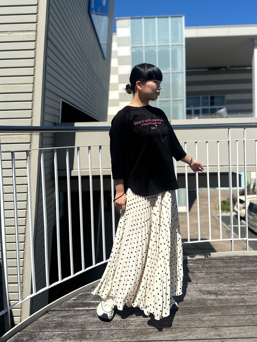 ブラック系のTシャツ/カットソー、ホワイト系のスカートを着用したレディースの春コーディネートの3枚目の写真