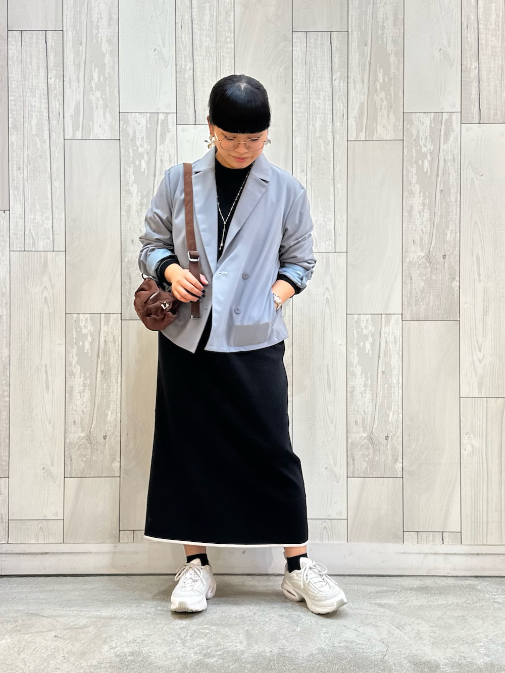 グレー系のテーラードジャケット、ブラック系のワンピース、ホワイト系のスニーカーを着用したレディースの秋コーディネートの2枚目の写真