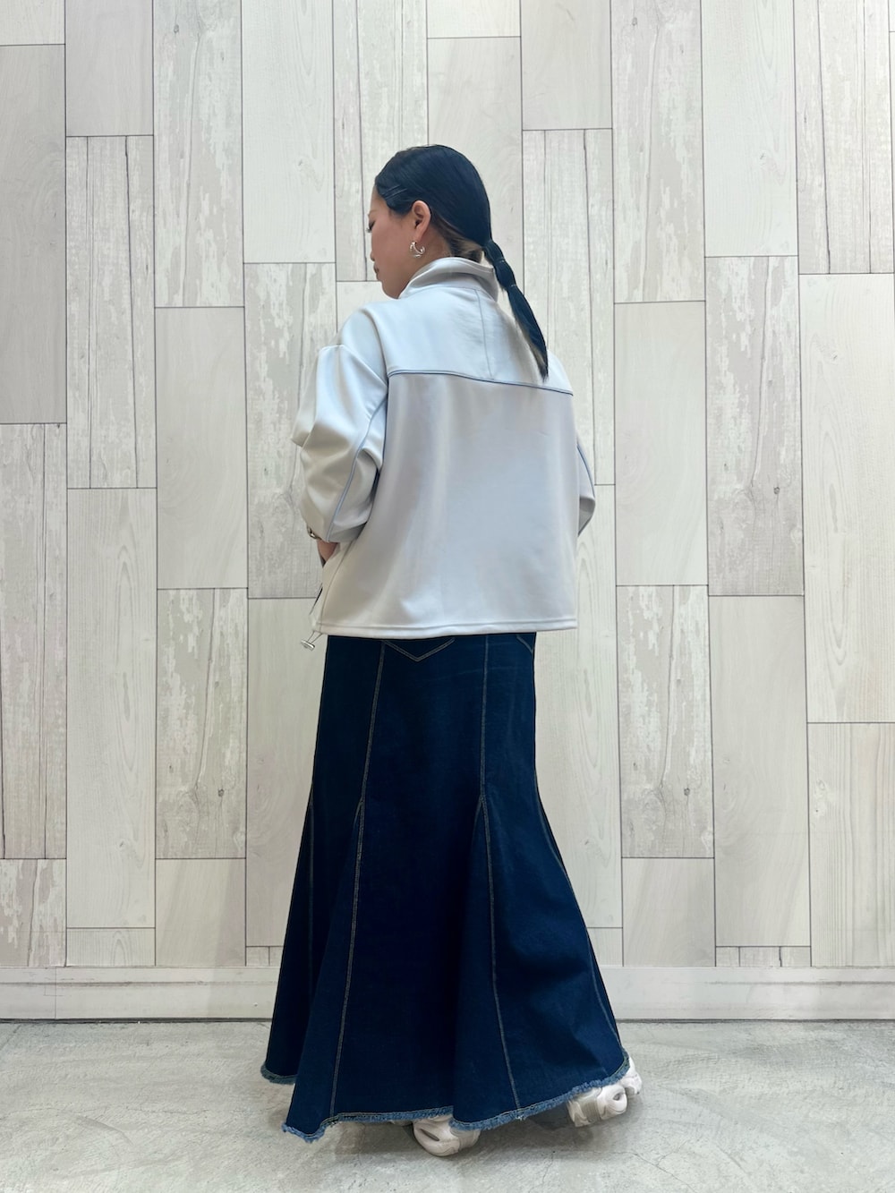 グレー系のその他アウター、ブルー系のデニムスカート、ホワイト系のスニーカーを着用したレディースの春コーディネートの4枚目の写真