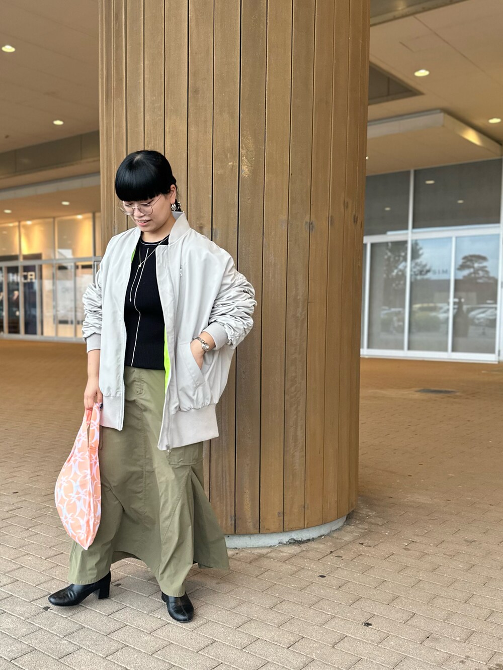 ブラック系のニット/セーター、ベージュ系のMA-1、グリーン系のスカートを着用したレディースの秋コーディネートの2枚目の写真