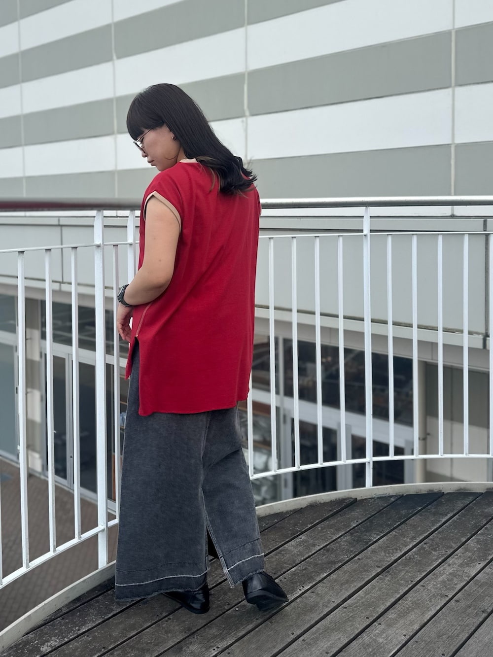 レッド系のTシャツ/カットソー、ブラック系のスカート、ブラウン系のローファーを着用したレディースの夏コーディネートの5枚目の写真