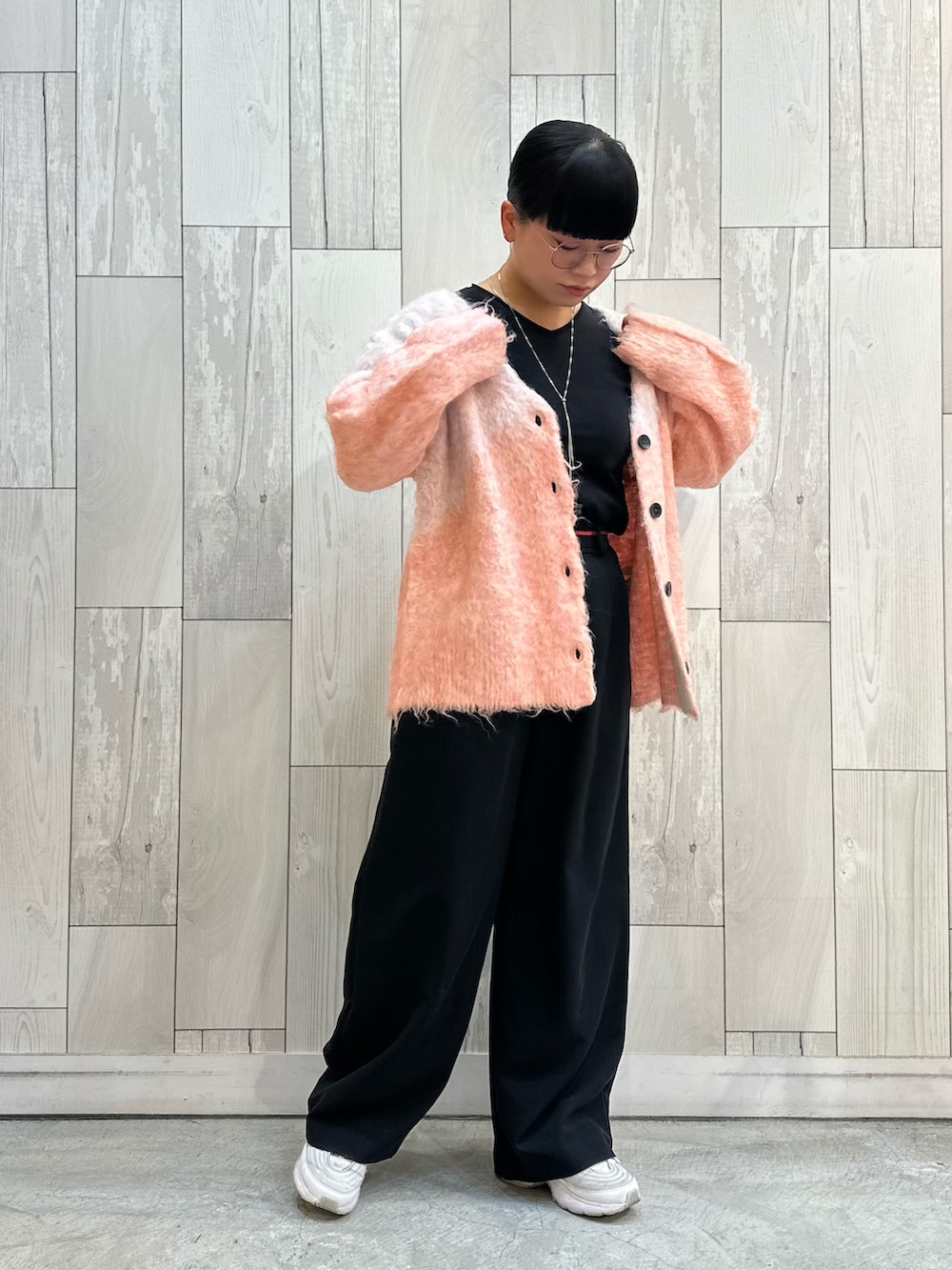 ピンク系のカーディガン/ボレロ、ブラック系のスラックス、ブラック系のTシャツ/カットソーを着用したレディースの冬コーディネートの3枚目の写真