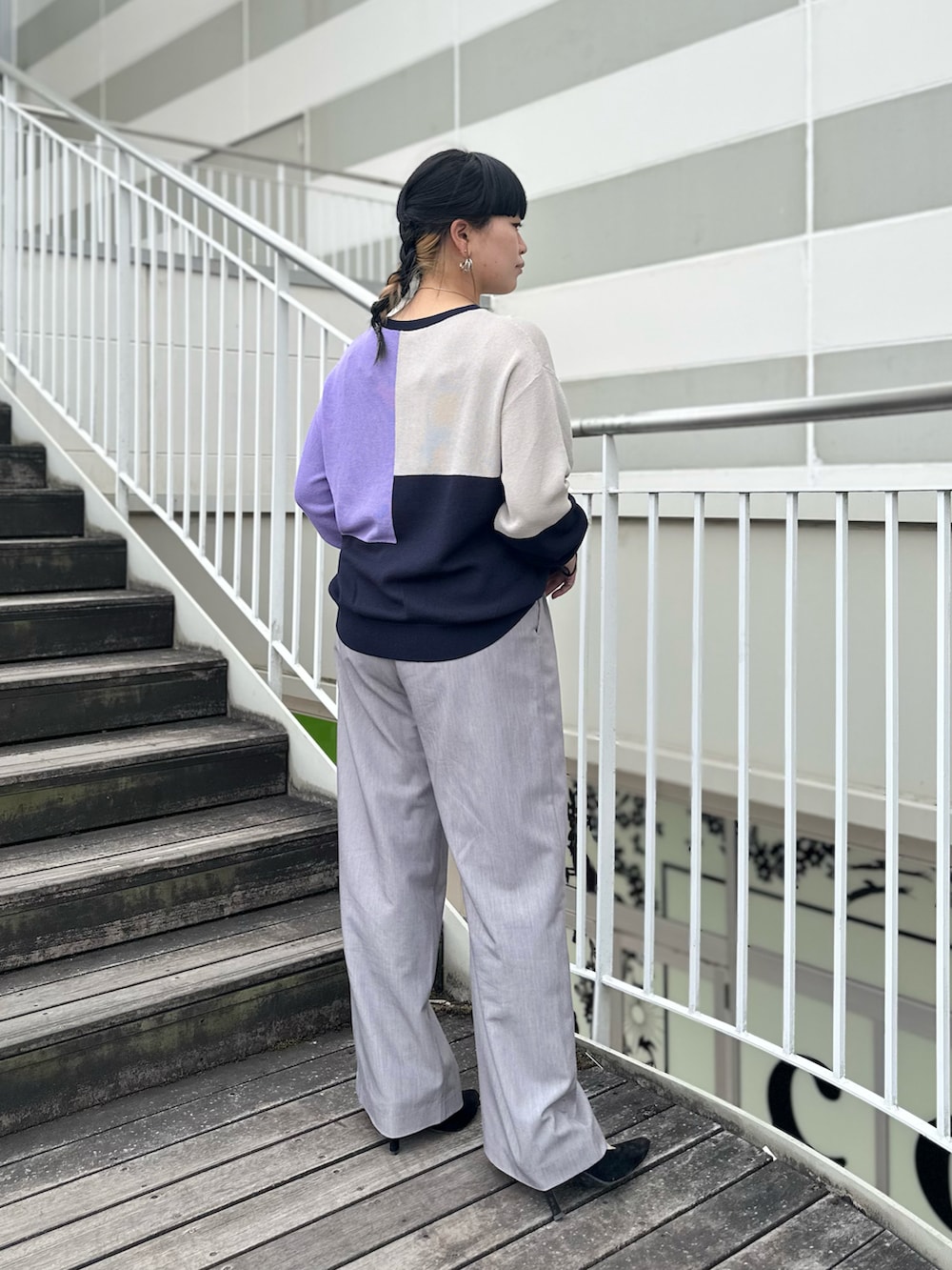 ブルー系のニット/セーター、グレー系のスラックスを着用したレディースの冬コーディネートの3枚目の写真