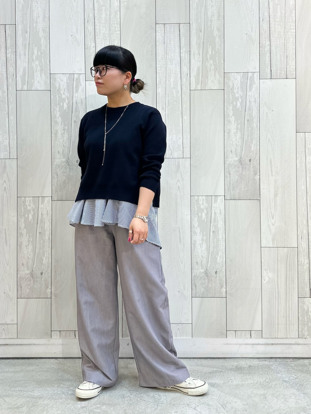 グレー系のスラックス、ホワイト系のスニーカーを着用したレディースの冬コーディネートの2枚目の写真