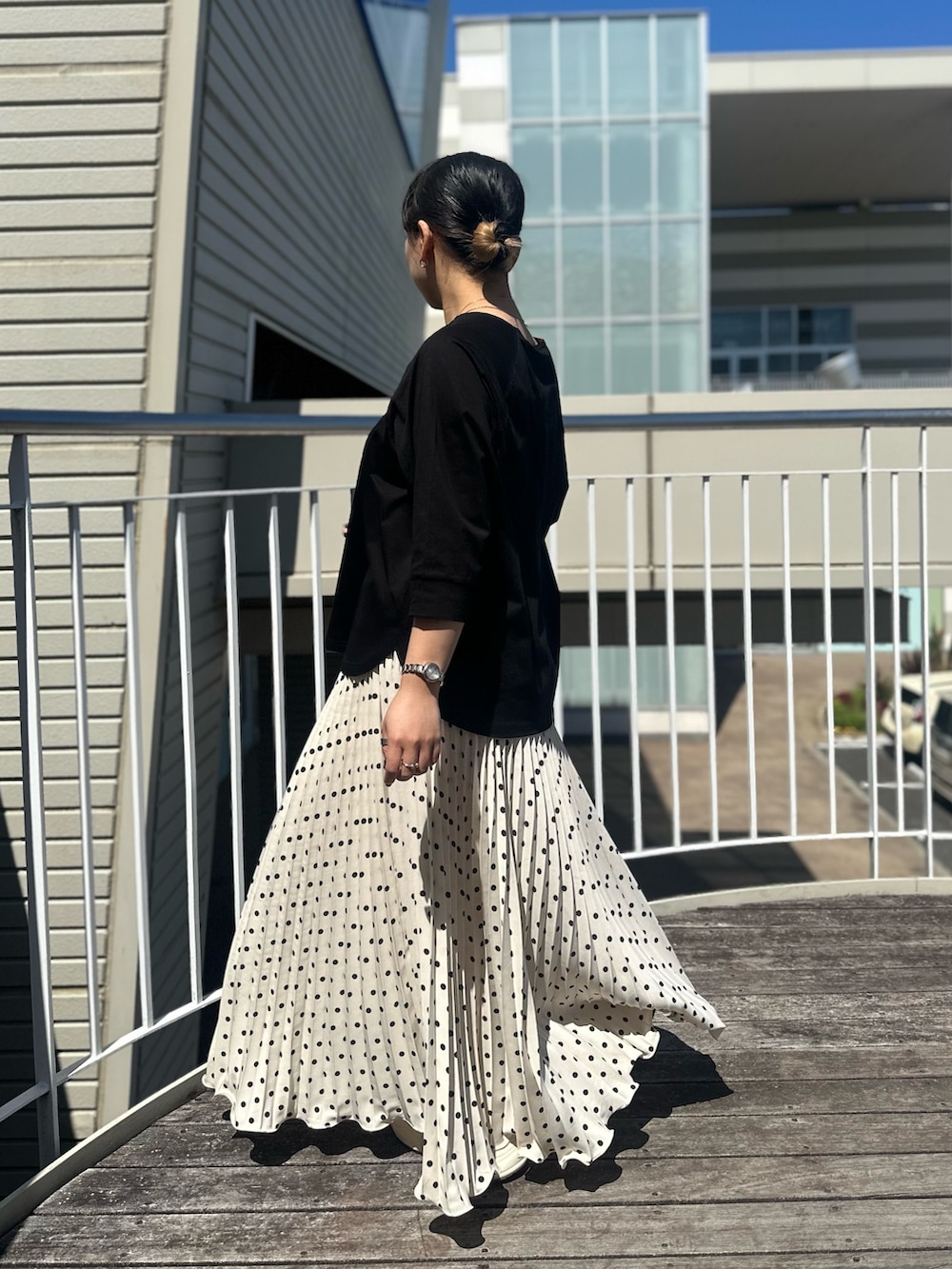 ブラック系のTシャツ/カットソー、ホワイト系のスカートを着用したレディースの春コーディネートの2枚目の写真