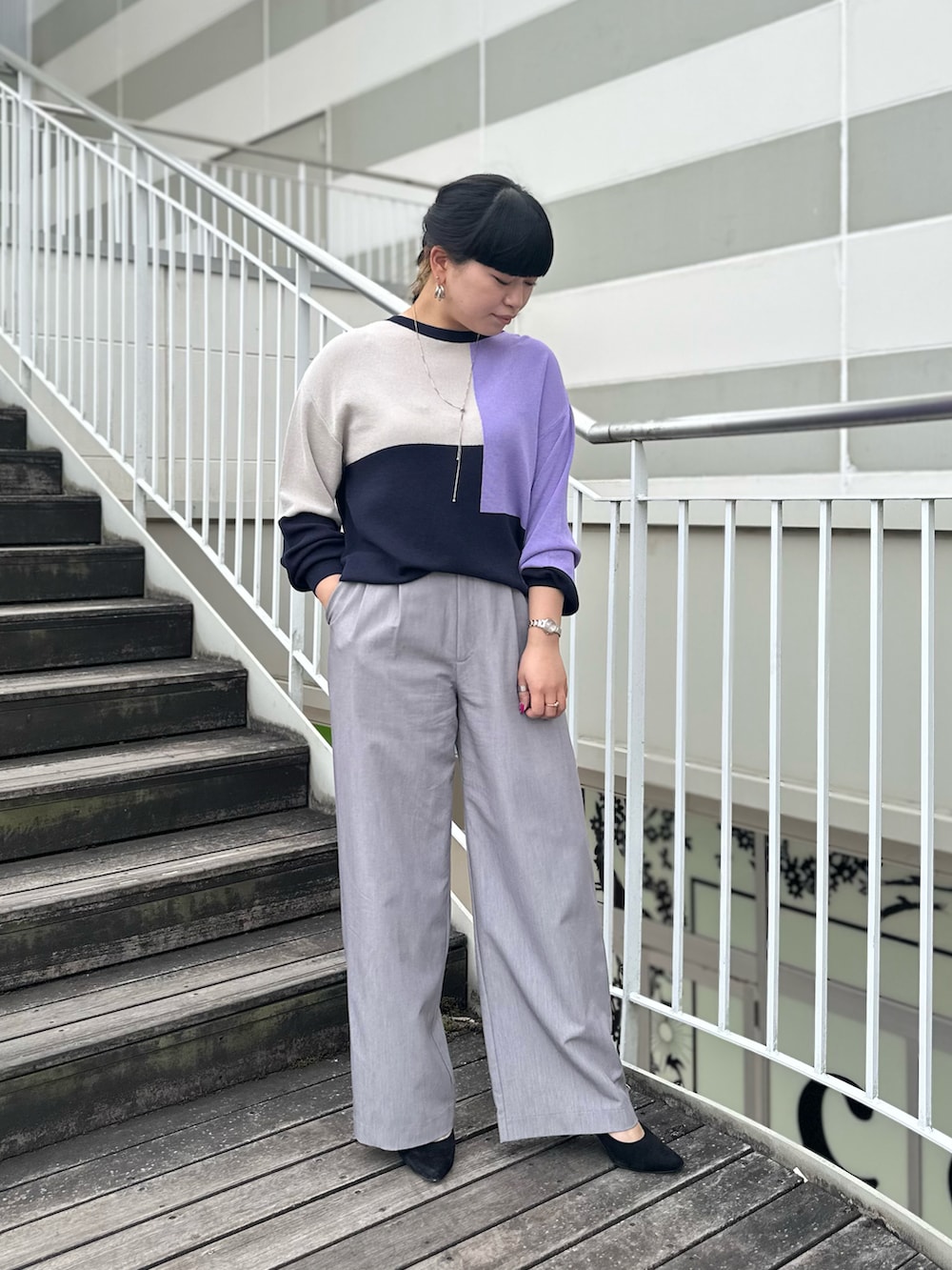 ブルー系のニット/セーター、グレー系のスラックスを着用したレディースの冬コーディネートの2枚目の写真