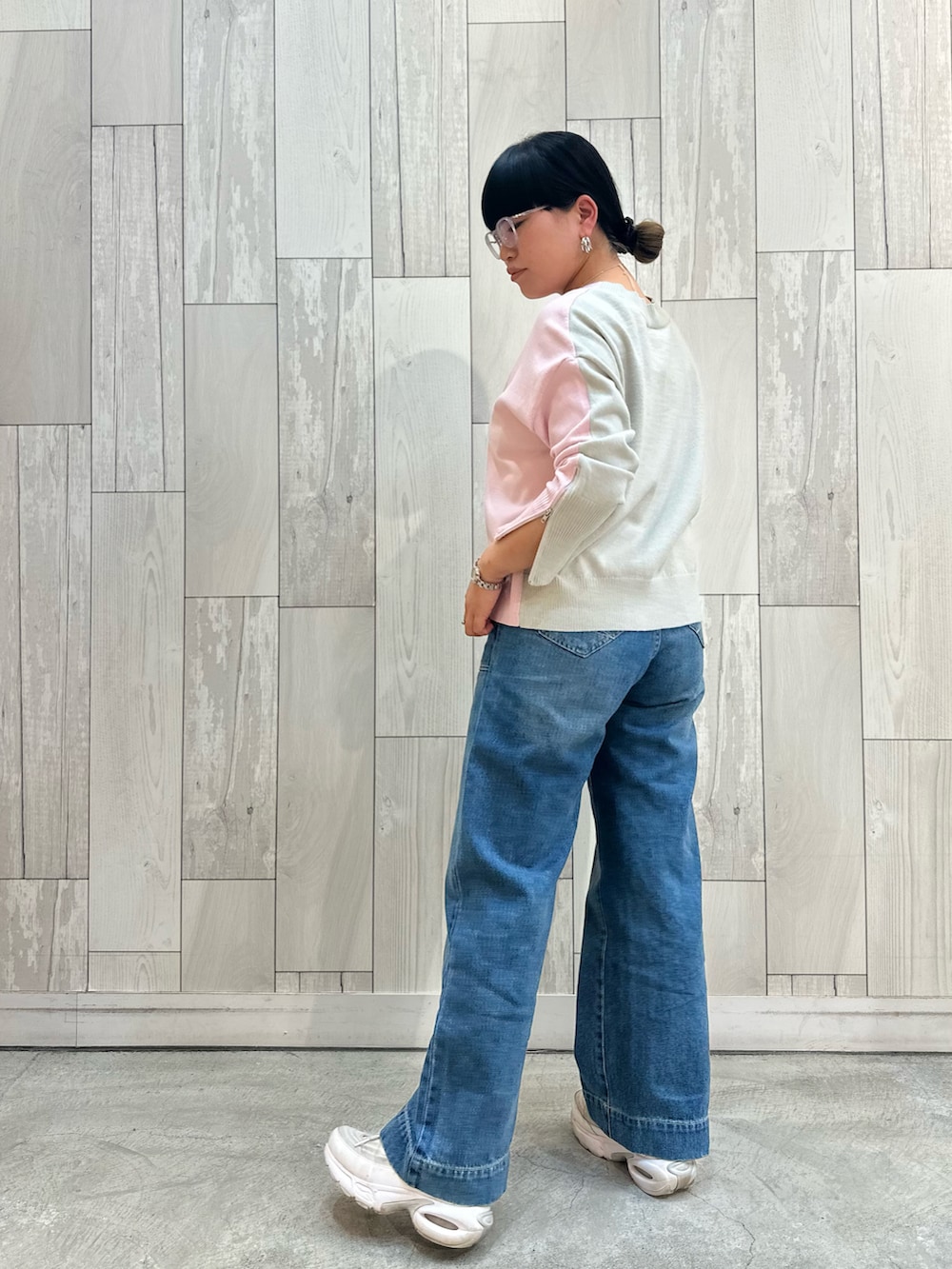 ピンク系のニット/セーター、ブルー系のデニムパンツ、ホワイト系のスニーカーを着用したレディースの冬コーディネートの3枚目の写真