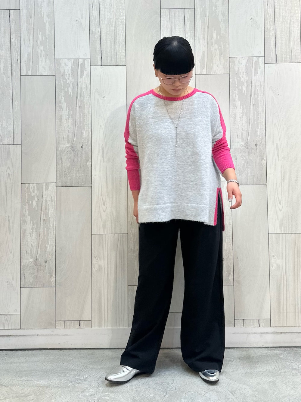 ブラック系のスラックス、シルバー系のローファー、グレー系のニット/セーターを着用したレディースの冬コーディネートの3枚目の写真