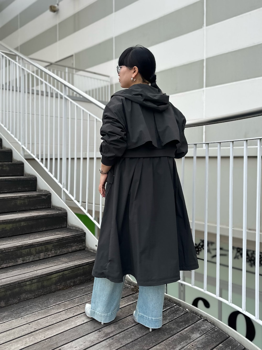 グレー系のミリタリージャケット、ブルー系のデニムパンツを着用したレディースの冬コーディネートの4枚目の写真