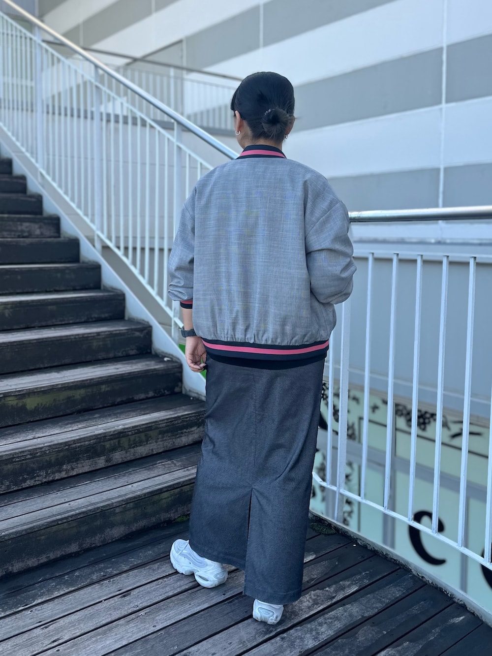 ブラック系のTシャツ/カットソー、ブラック系のブルゾン、グレー系のスカートを着用したレディースの秋コーディネートの3枚目の写真