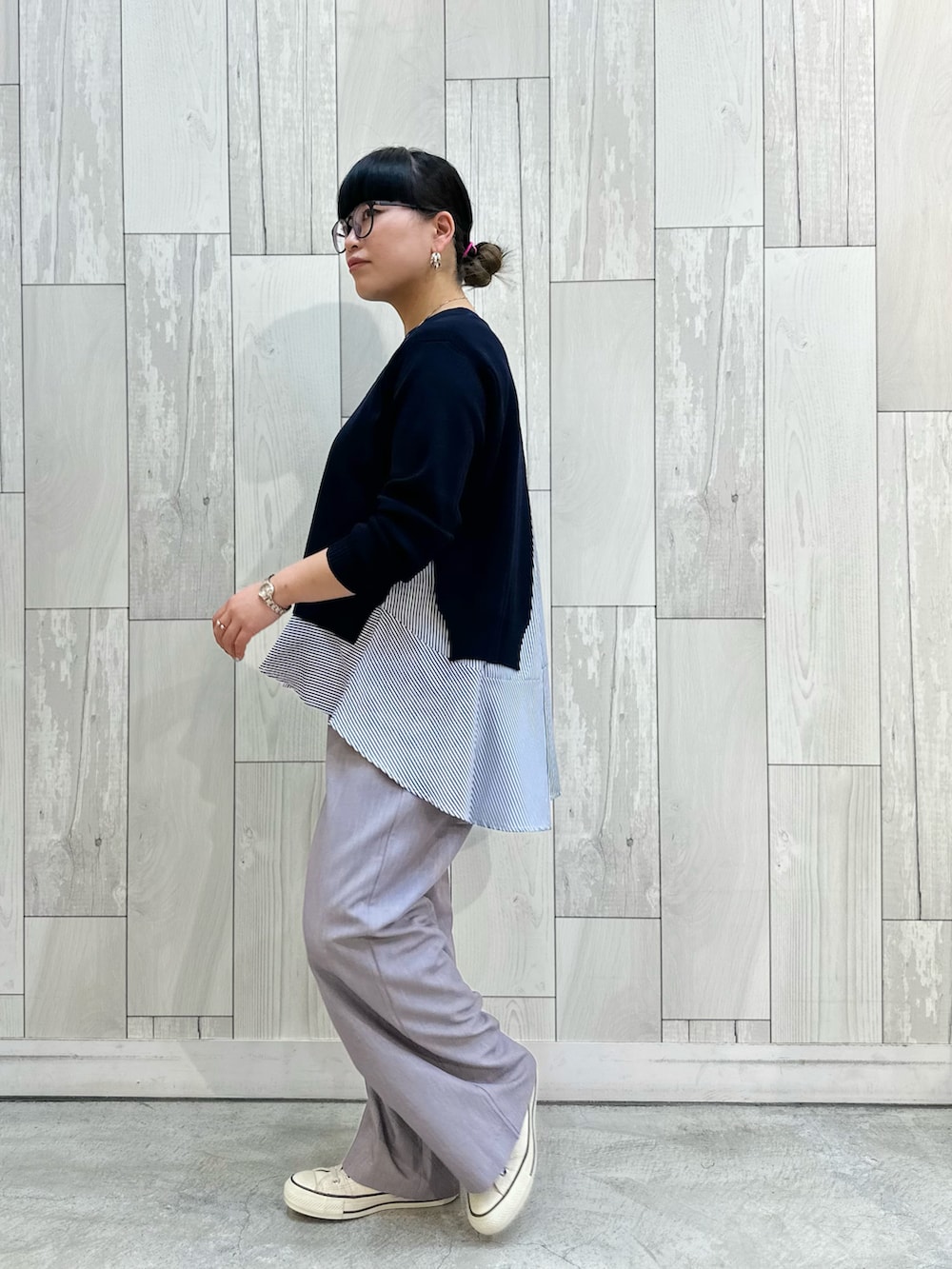 グレー系のスラックス、ホワイト系のスニーカーを着用したレディースの冬コーディネートの3枚目の写真