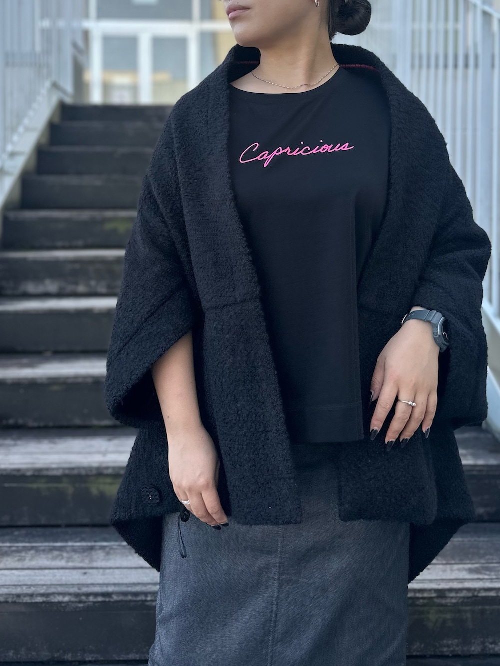 ブラック系のTシャツ/カットソー、グレー系のスカート、ホワイト系のスニーカーを着用したレディースの秋コーディネートの7枚目の写真