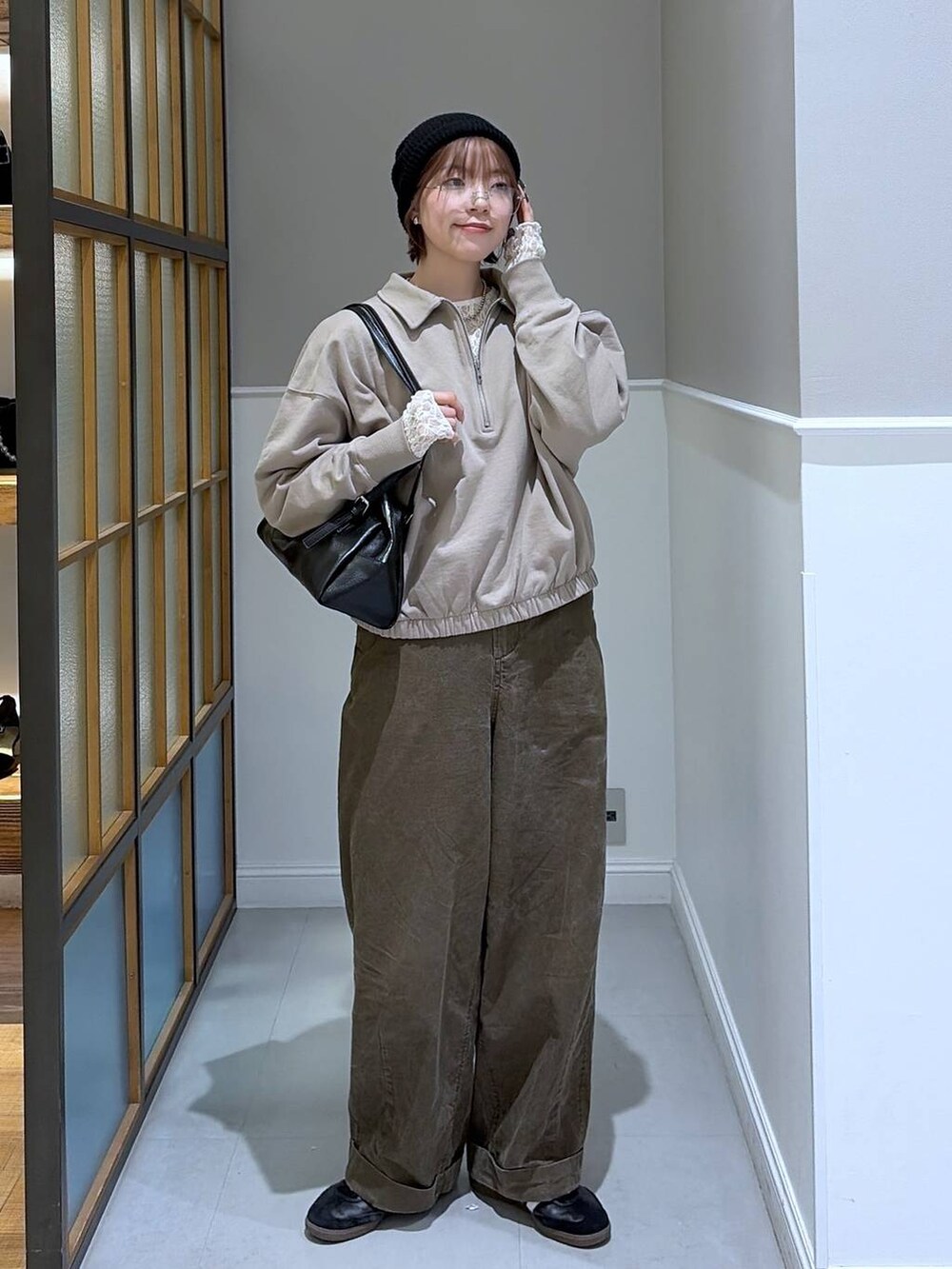 ブラック系のボストンバッグ、ブラウン系のその他パンツ、ホワイト系のTシャツ/カットソーを着用したレディースの冬コーディネートの2枚目の写真