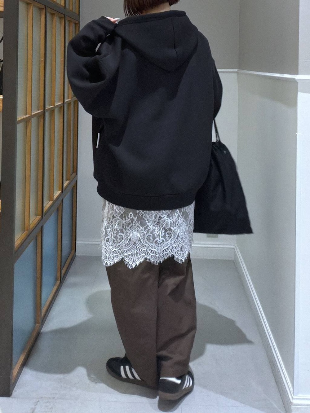 ブラック系のパーカー、ブラック系のTシャツ/カットソー、ブラック系のトートバッグを着用したレディースの春コーディネートの2枚目の写真