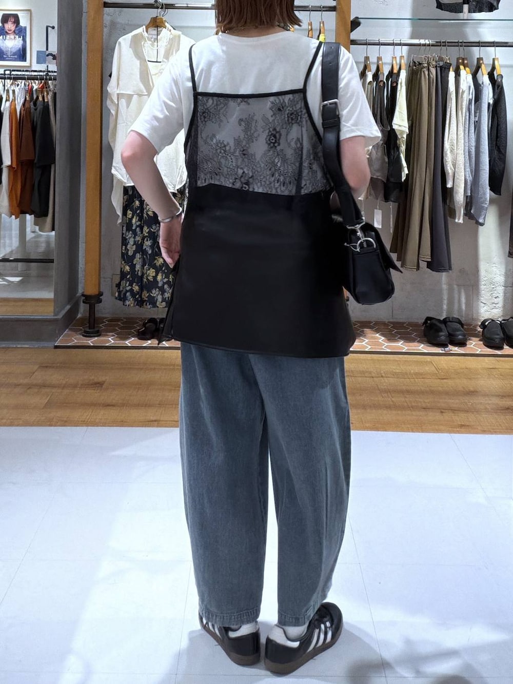 ブラック系のショルダーバッグ、ブルー系のデニムパンツ、ホワイト系のTシャツ/カットソーを着用したレディースの夏コーディネートの2枚目の写真