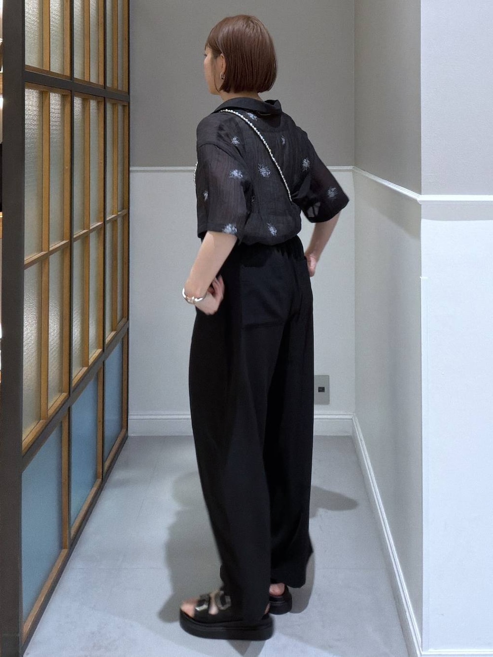 ブラック系のその他パンツ、ブラック系のサンダル、シルバー系のショルダーバッグを着用したレディースの春コーディネートの2枚目の写真
